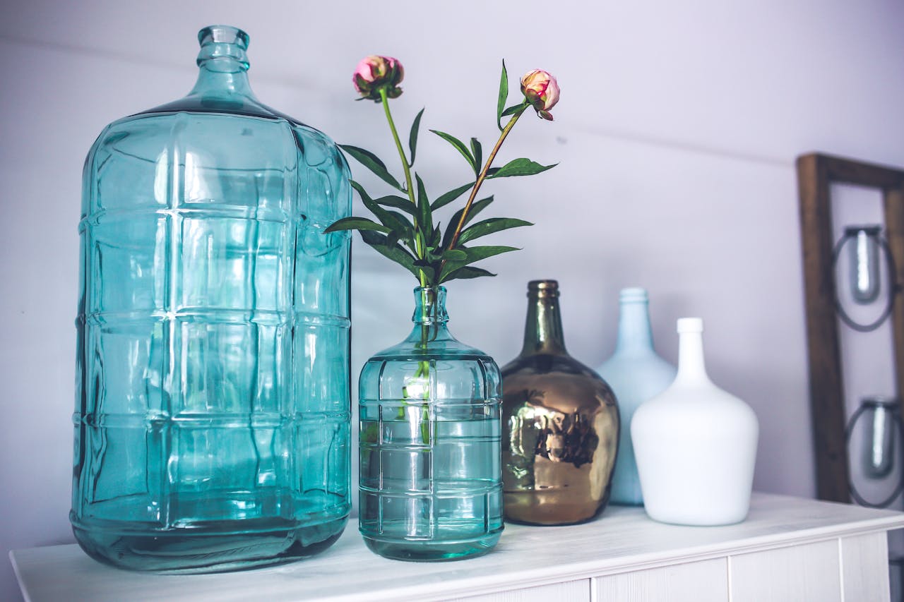 Decorative glass vases and peonies create an elegant home decor ambiance.