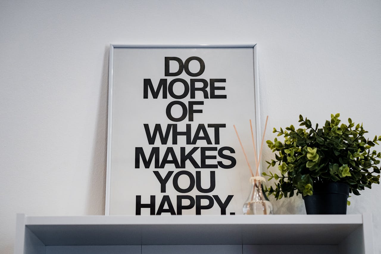 Framed quote 'Do More of What Makes You Happy' with plant and aroma diffuser.