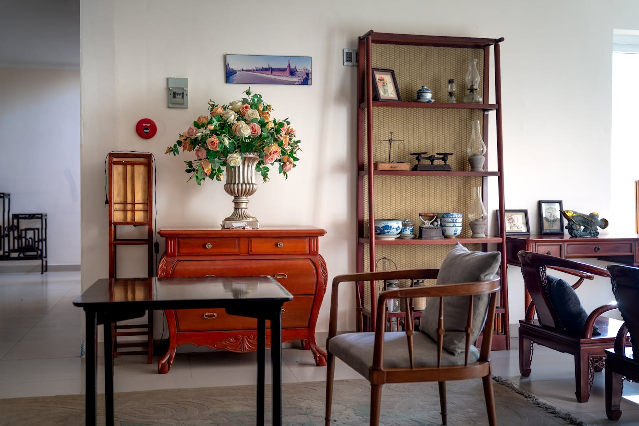 Classic living room interior featuring a floral bouquet, wooden furniture, and decorative ceramics.