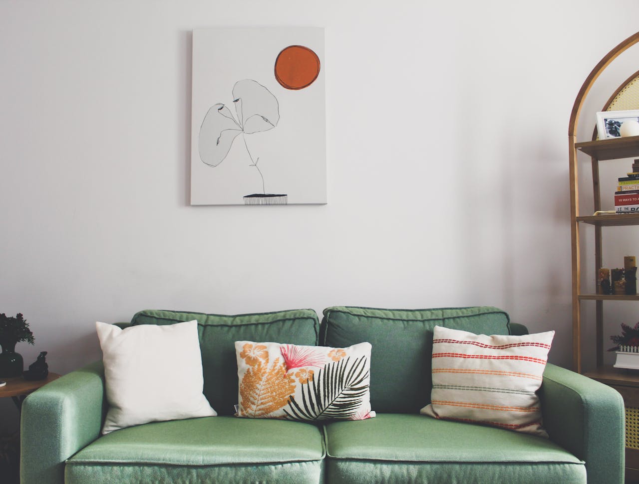 Elegant living room with a green sofa, decorative pillows, and minimalistic art in Istanbul.