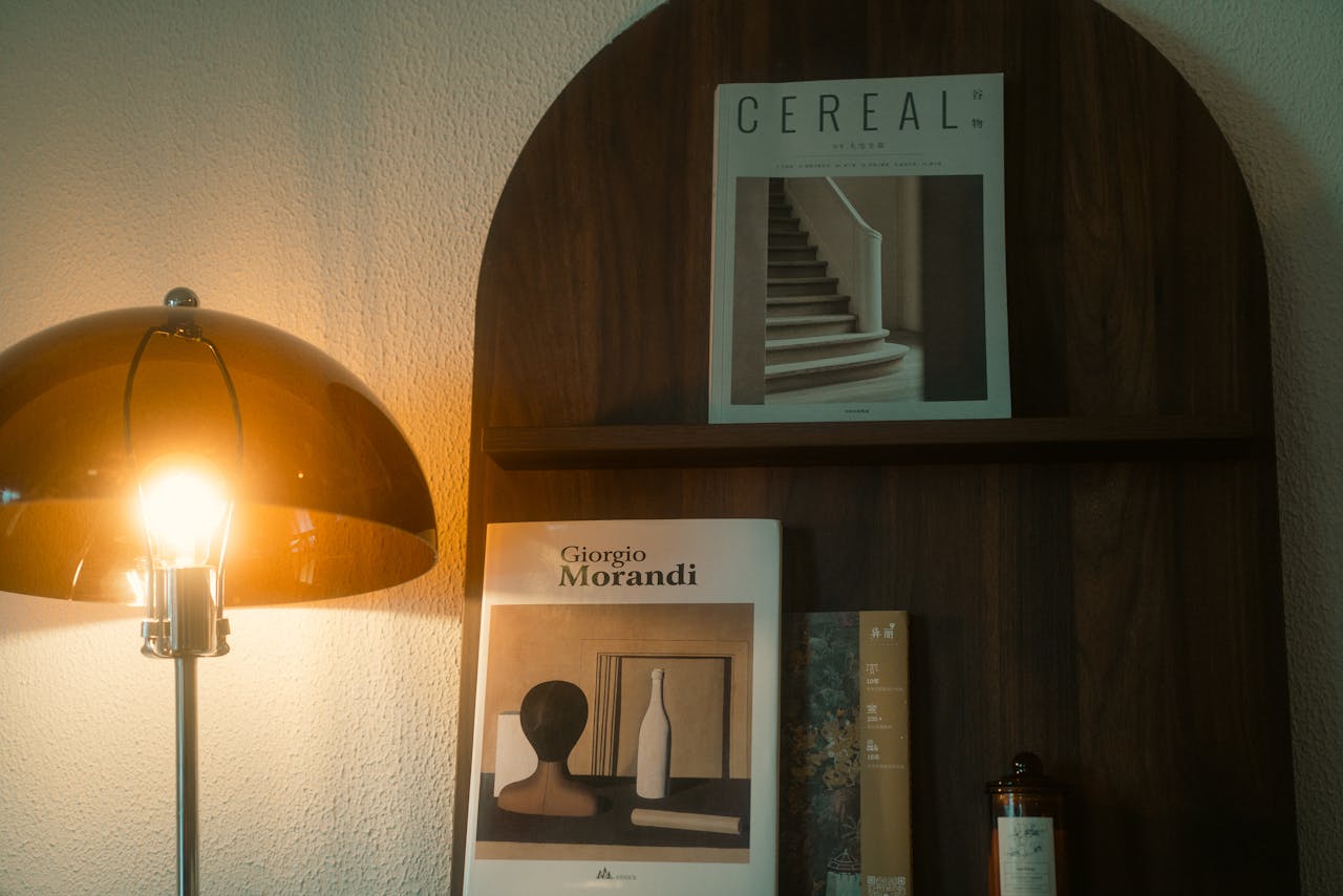 services-img An elegant setup featuring a modern lamp and art books on a wooden shelf, perfect for interior design inspiration.