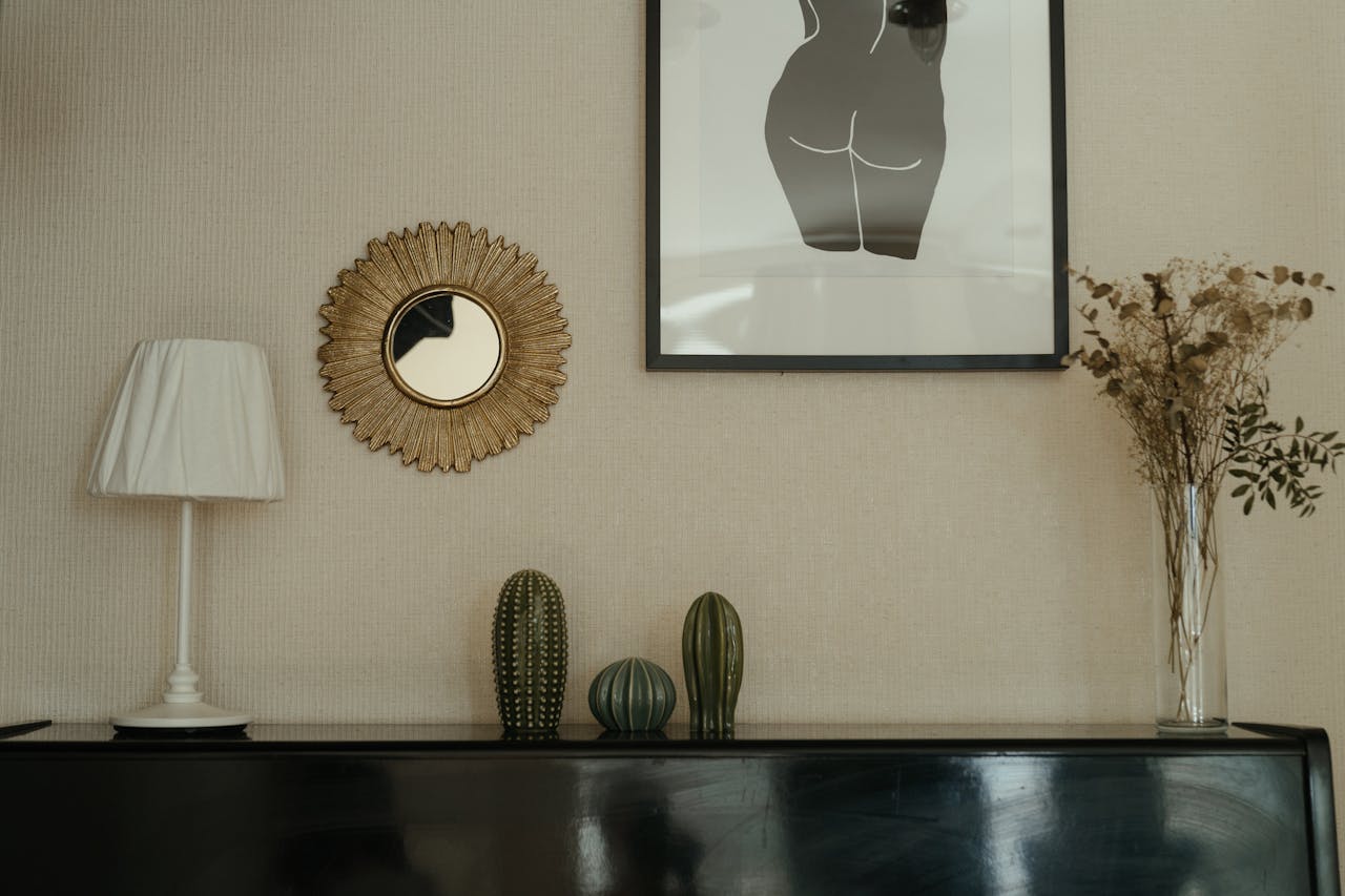 Elegant bedroom interior with decor elements like cacti, wall art, and a rustic mirror. Ideal for modern home inspiration.