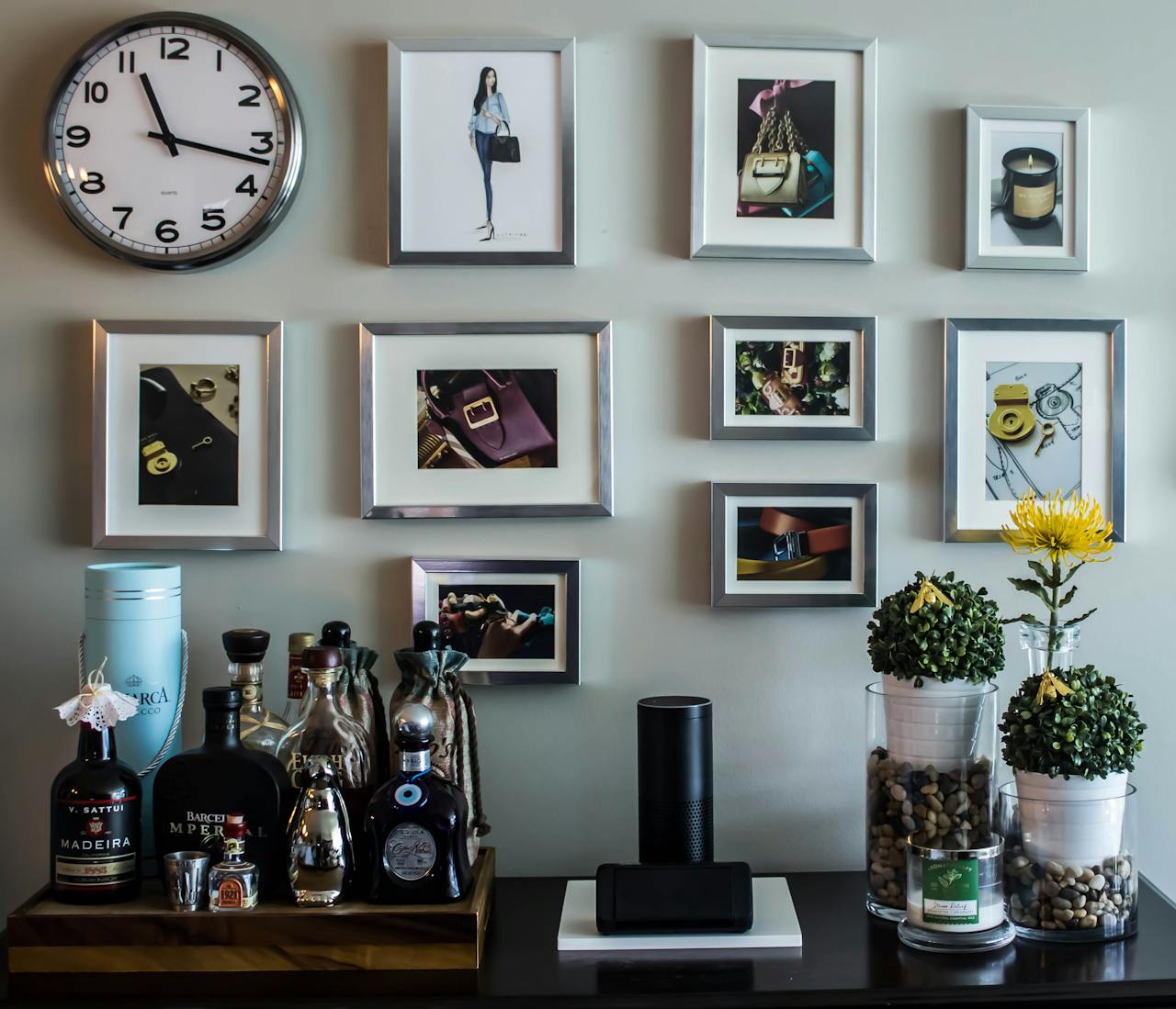 Chic interior featuring a wall clock, framed art, and elegant decor accents on a side table.
