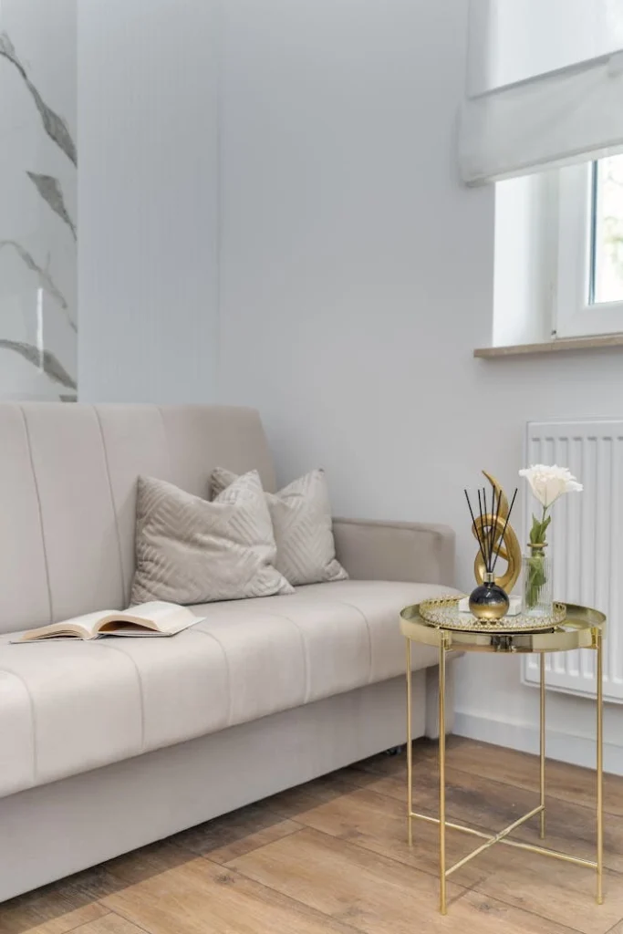 Stylish Neutral Living Room Decor Beige sofa with pillows and gold coffee table by window
